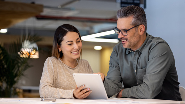 Male and female looking at a tablet